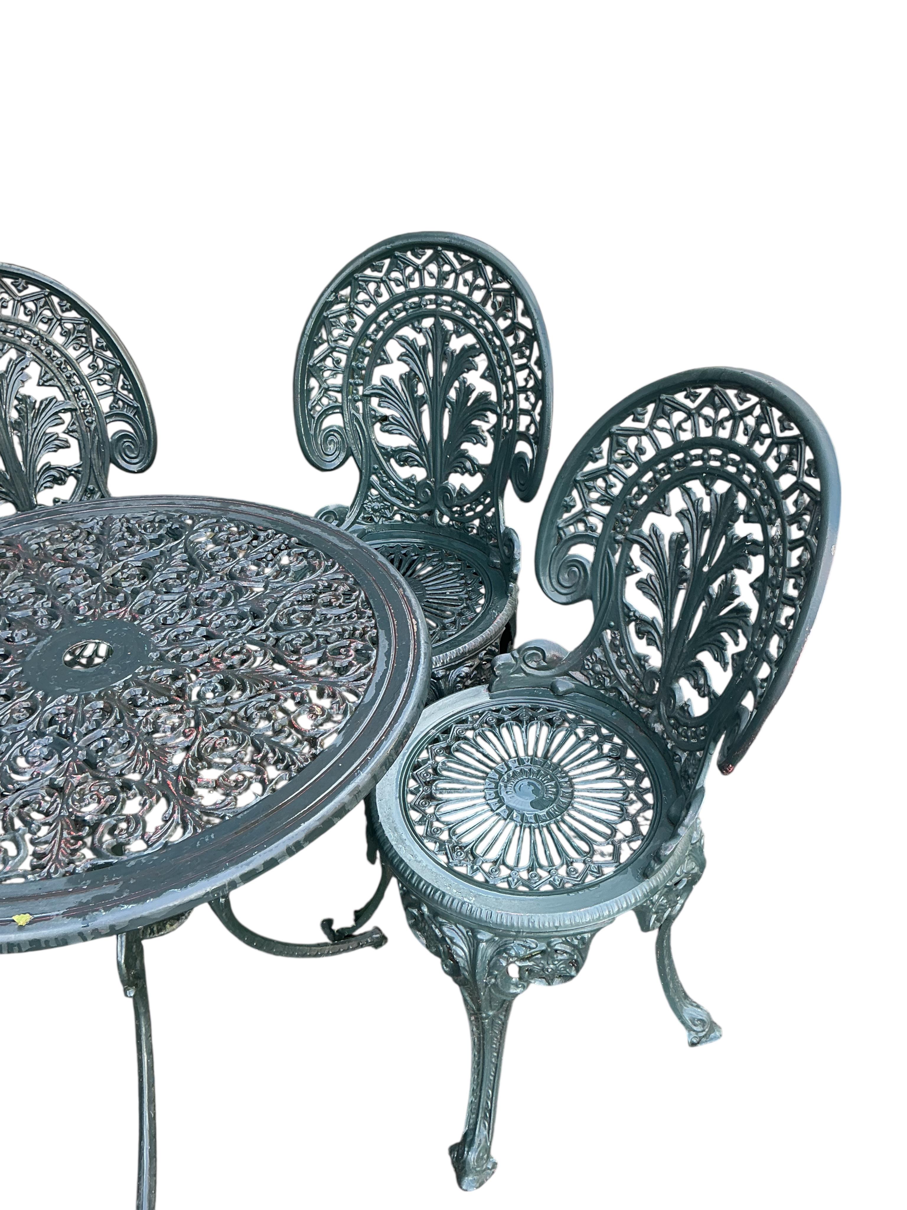 A Victorian style circular painted aluminium garden table, diameter 68cm, height 64cm together with four chairs